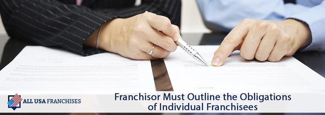 Franchisor Pointing With a Pen to a Section on the Document Outlining the Obligations of the Franchisee