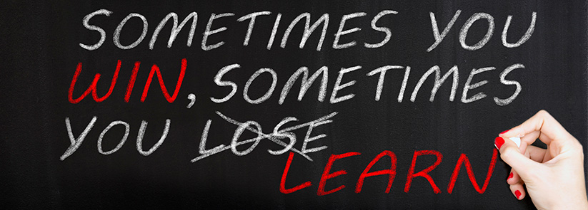 Person Writing in Chalk, 'Sometimes You Win, Sometimes You (Lose Is Struckthrough) Learn'